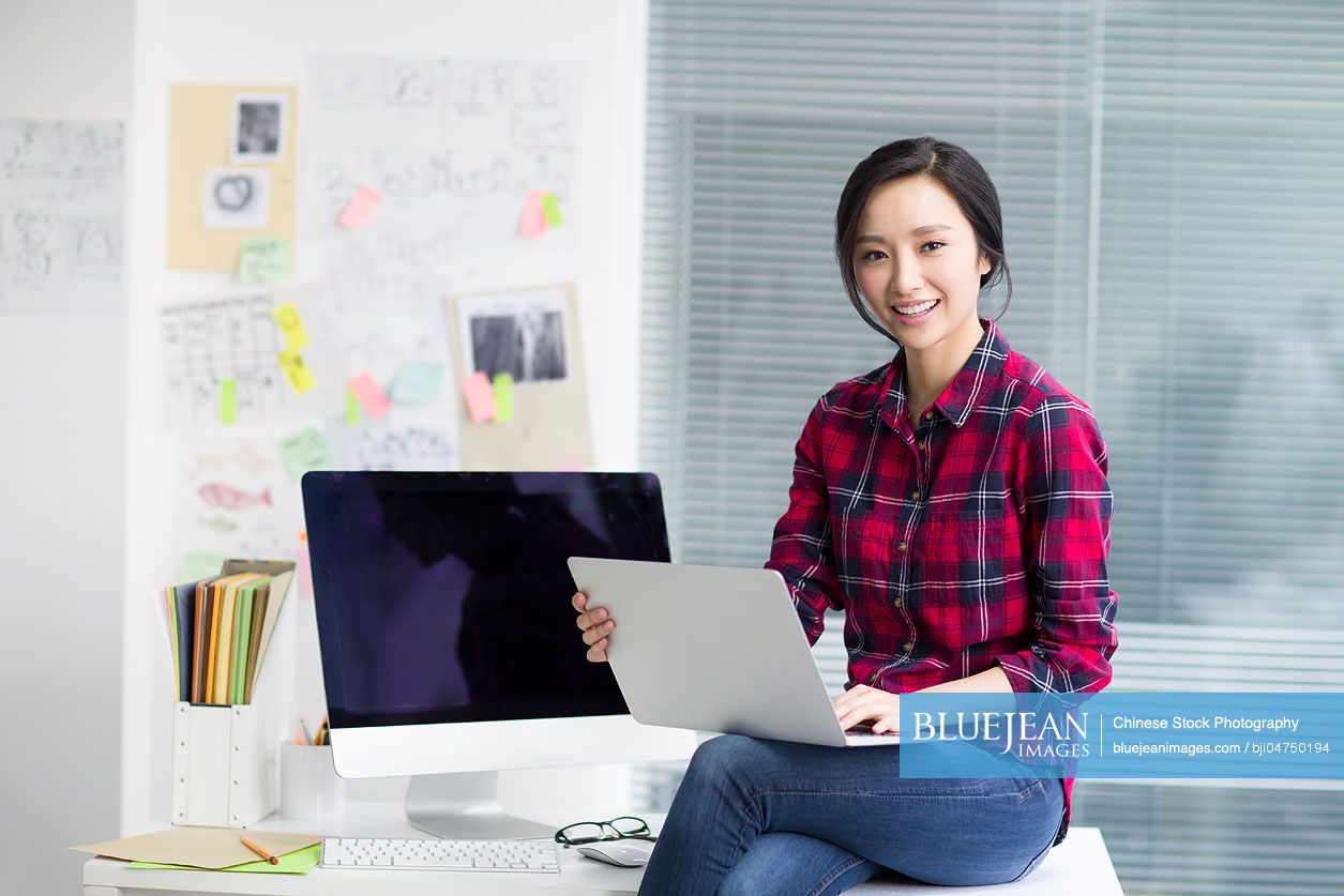 Portrait of young Chinese woman in office