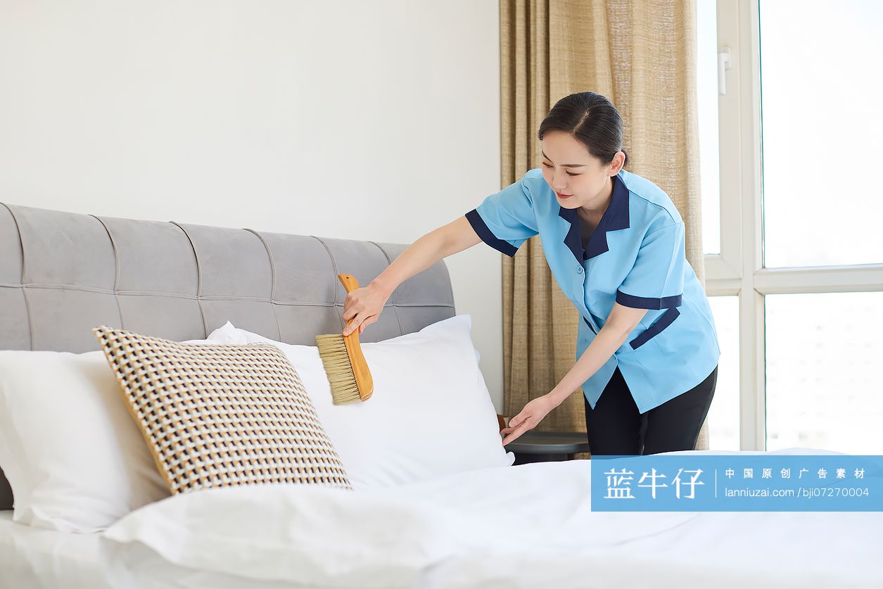 家政人员整理卧室床铺