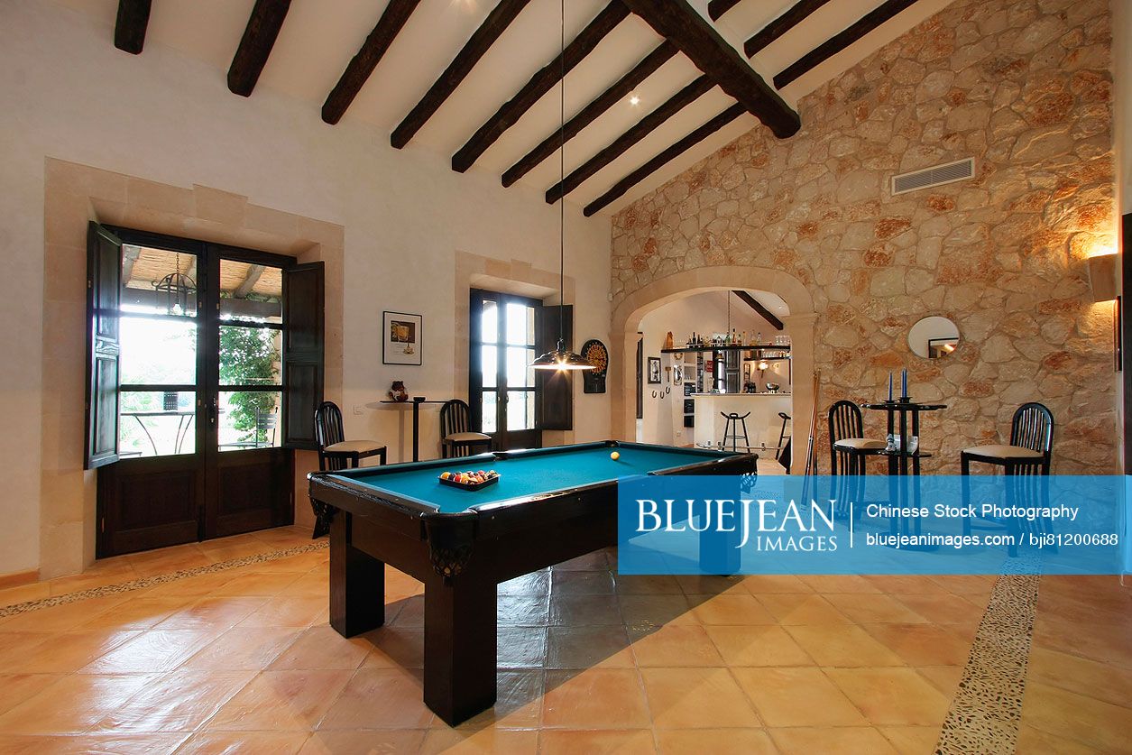 Wooden ceiling beams and pool table in Spanish style home