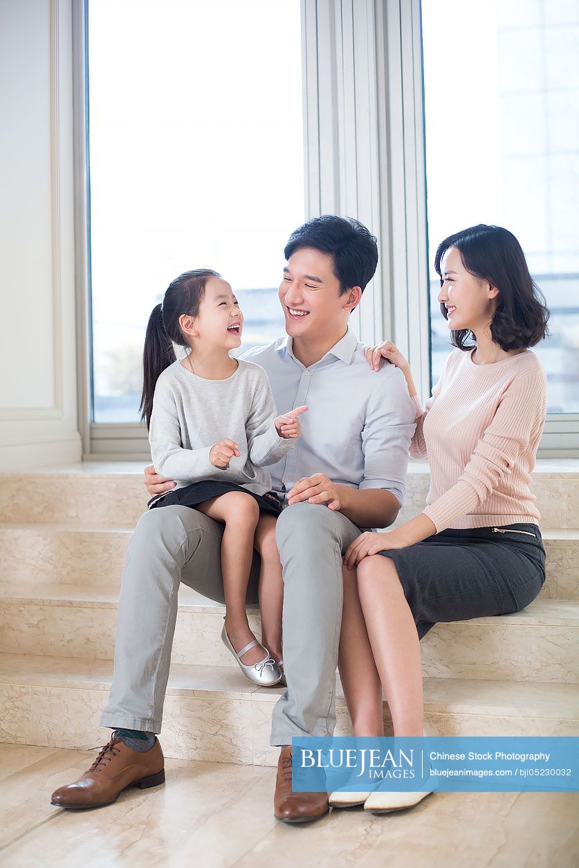 Cheerful Chinese family chatting in the living room