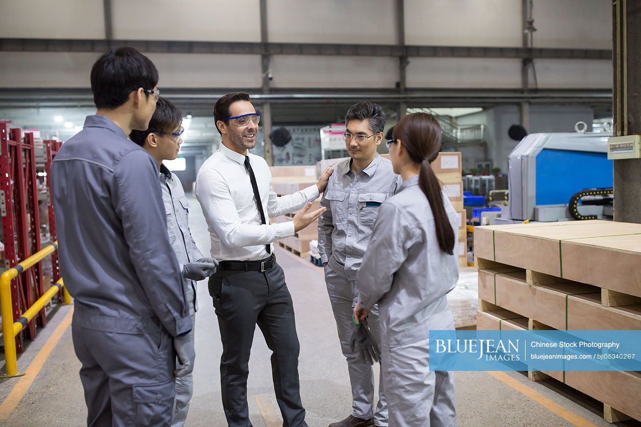 Businessman and engineers talking in the factory