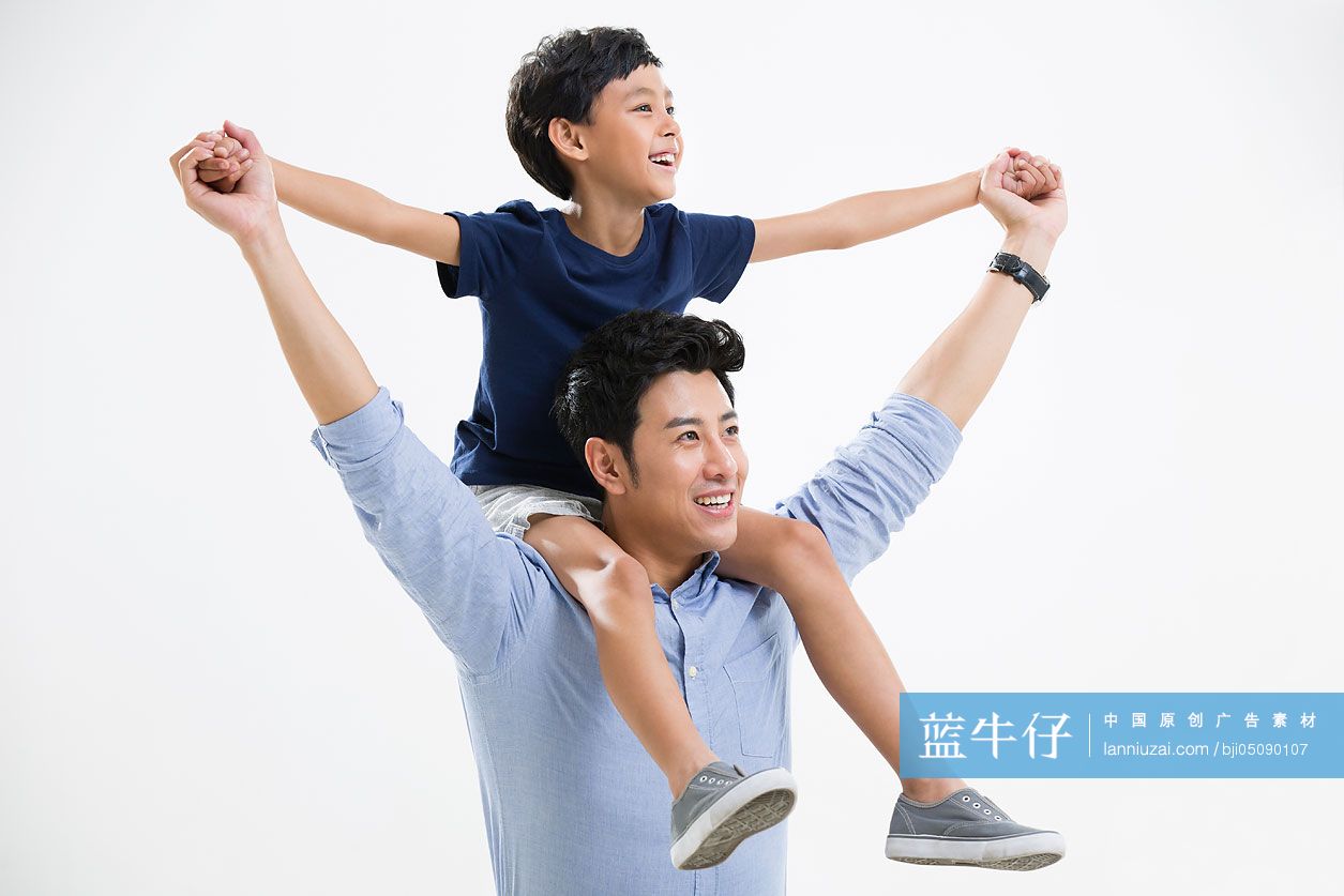 快乐的男孩坐在爸爸肩上