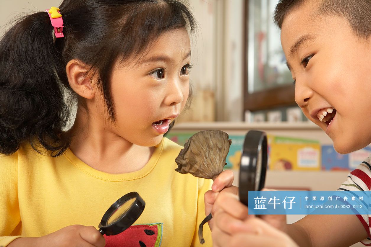 小女孩和小男孩用放大镜看物体
