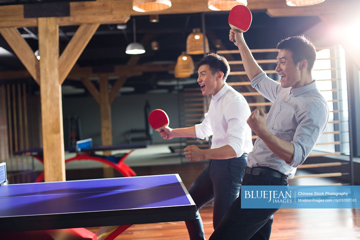 Young Chinese businessmen playing ping pong