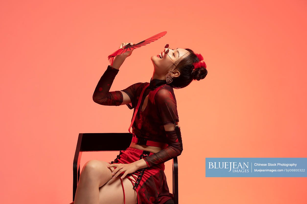 Beautiful young Chinese woman holding a fan