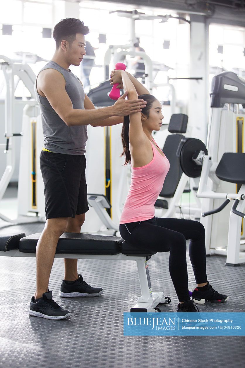 Young Chinese woman working with trainer at gym-High-res stock photo ...