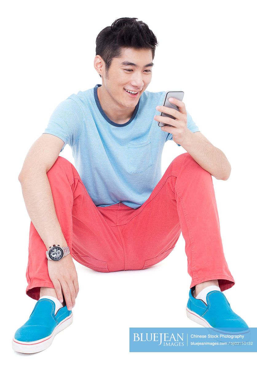 Happy young Chinese man and a mobile phone