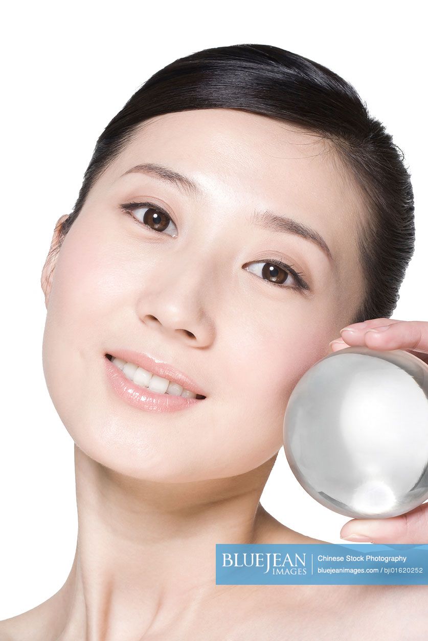 Beauty shot of a young Chinese woman holding a crystal ball