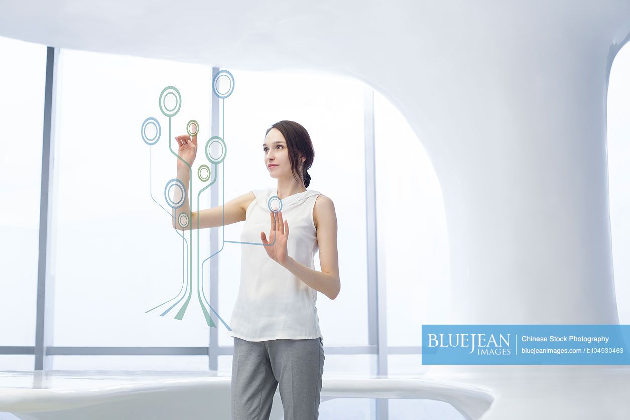 Businesswoman using advanced touch screen technology in office-High-res ...