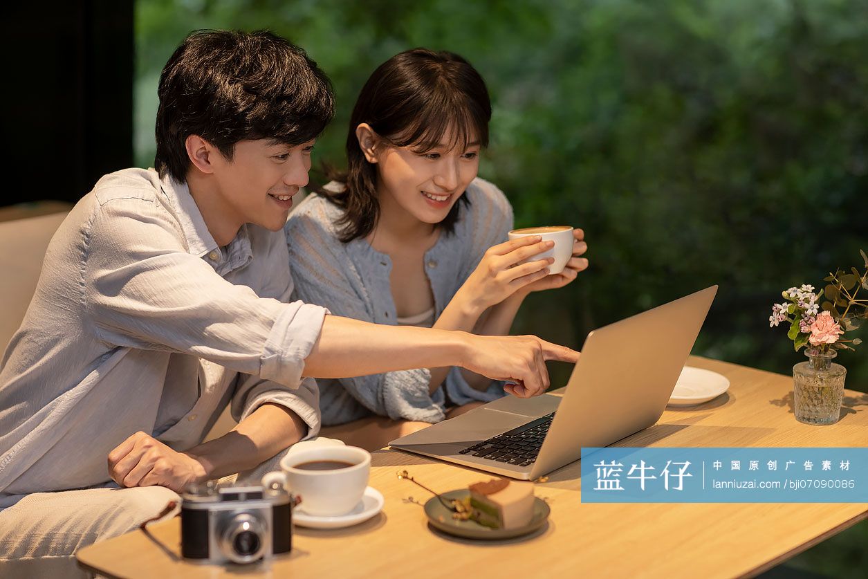 年轻情侣在咖啡馆使用笔记本电脑-蓝牛仔影像-中国原创广告影像素材