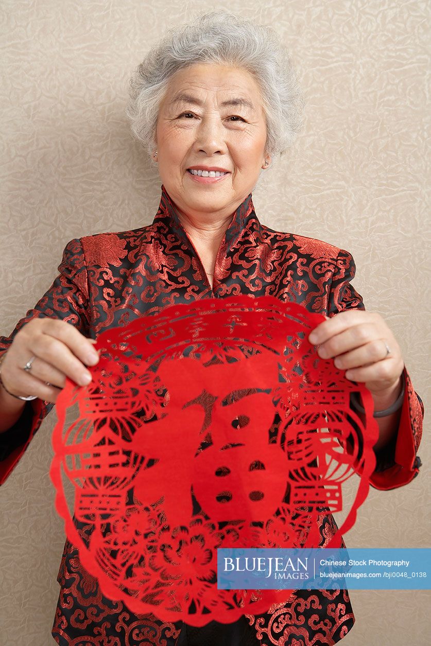 Chinese women holding paper cutting which symbolizes luck