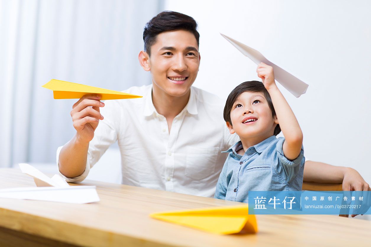 父亲和儿子一起折纸飞机