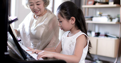 Chinese grandmother teaching granddaughter to play the piano,4K
