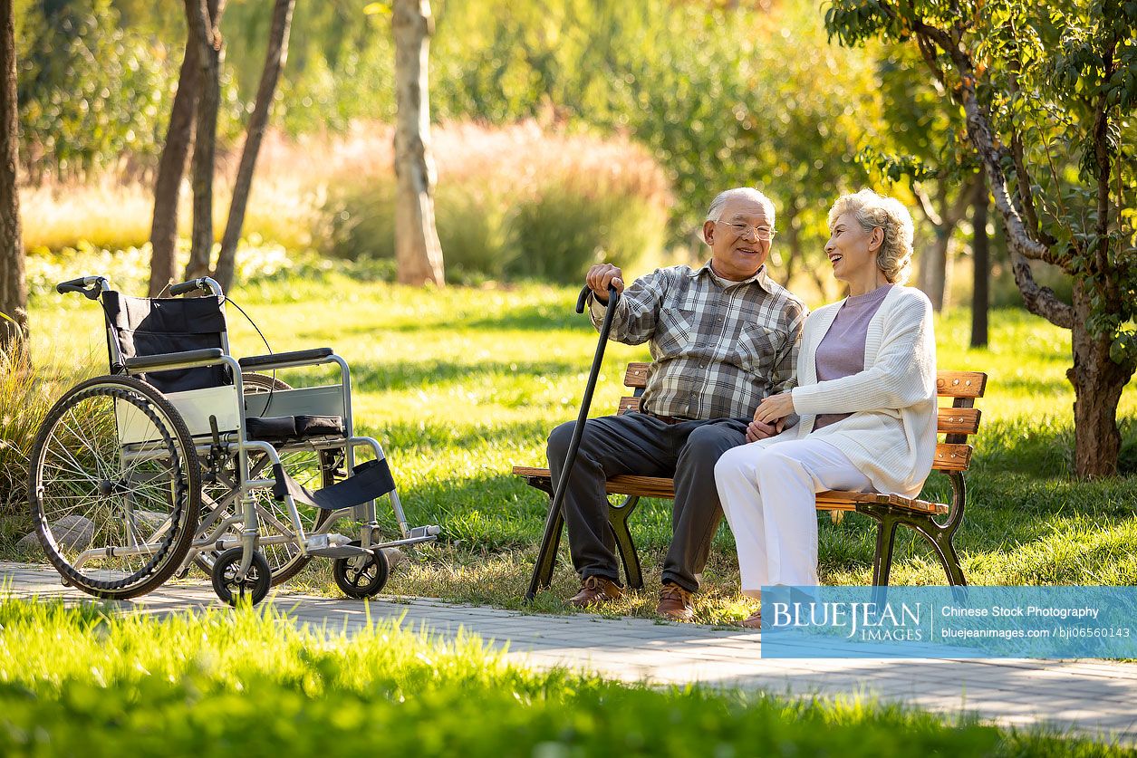 Cheerful senior Chinese couple relaxing in the park