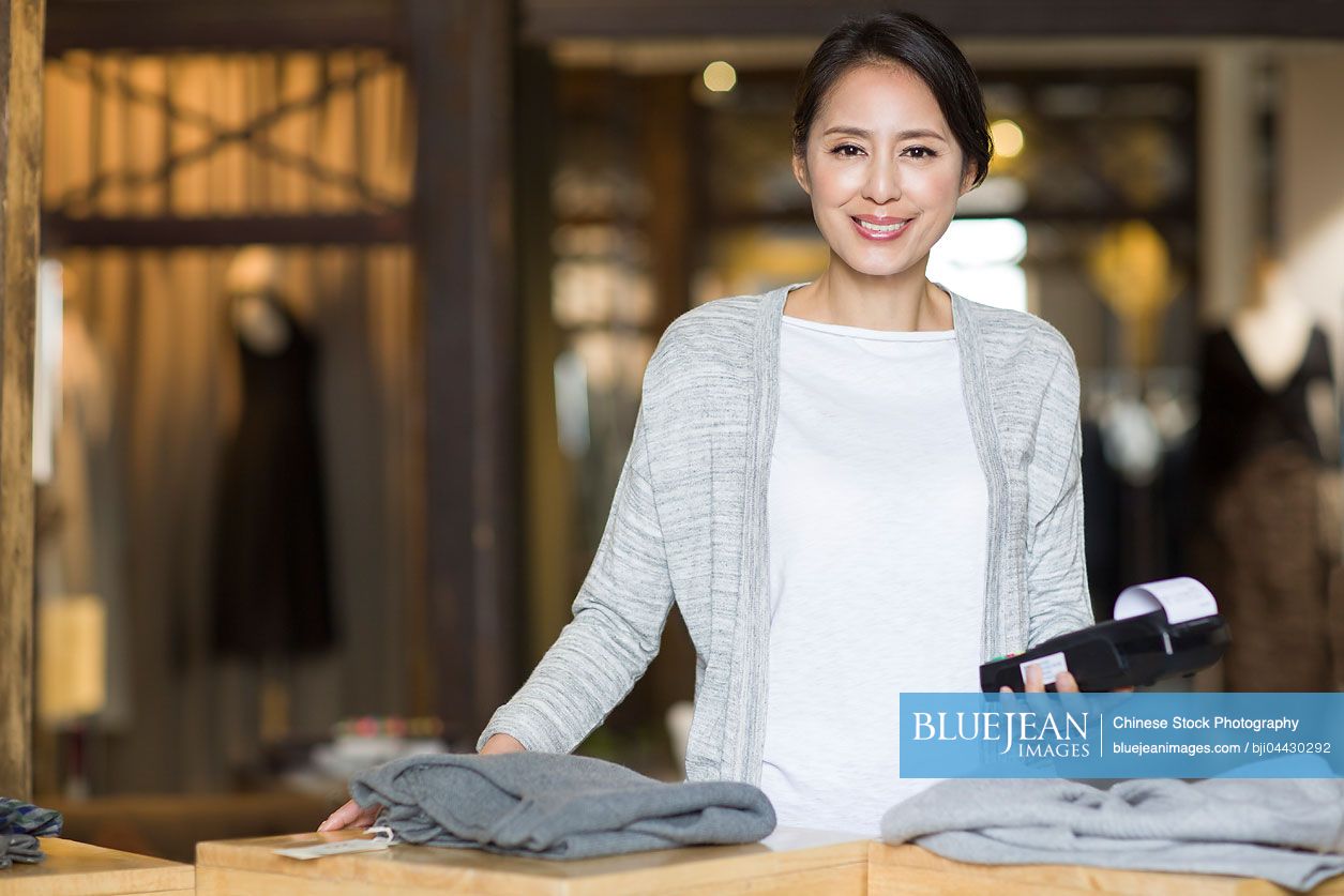 Chinese clothing store owner with credit card reader