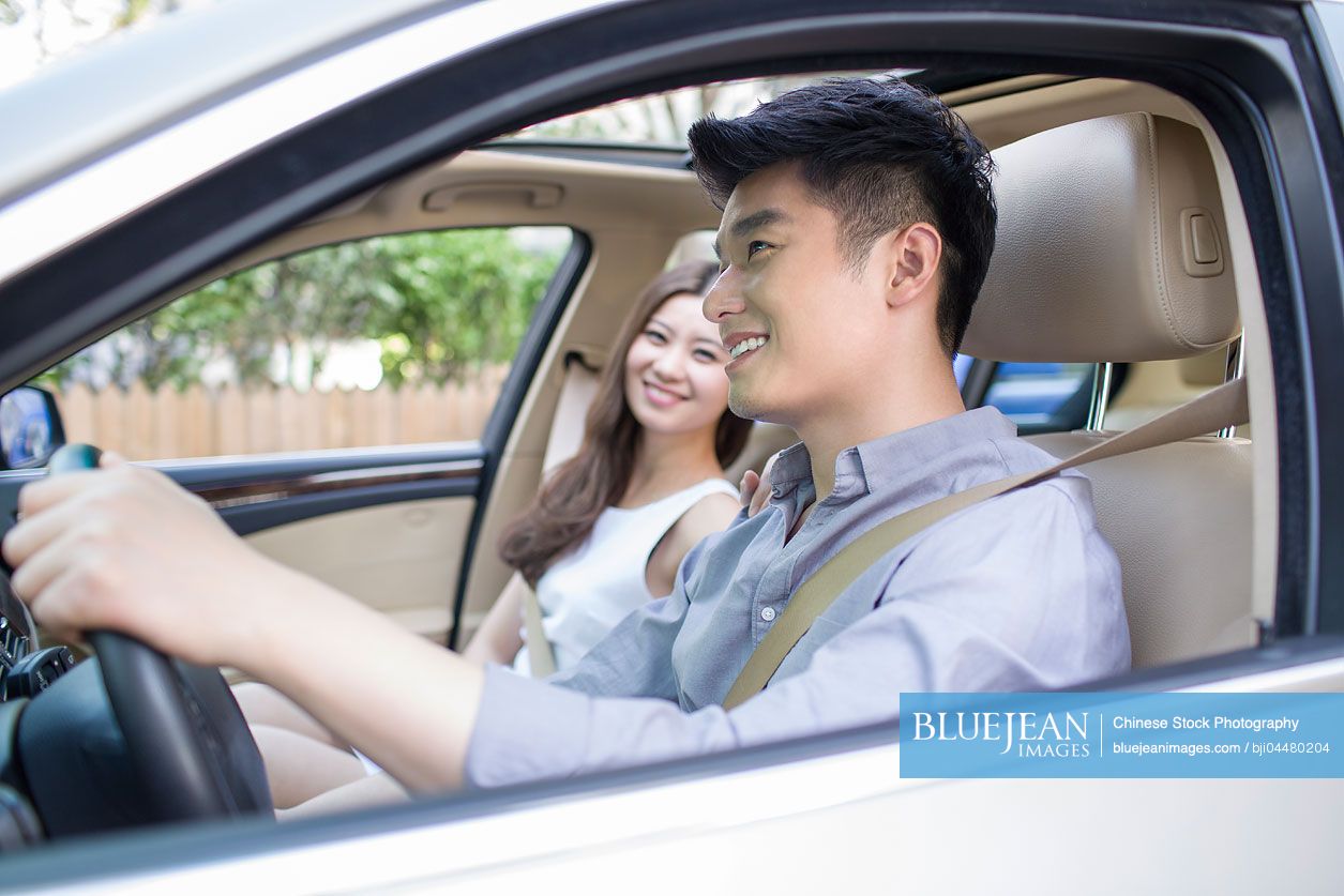 Happy young Chinese couple in a car