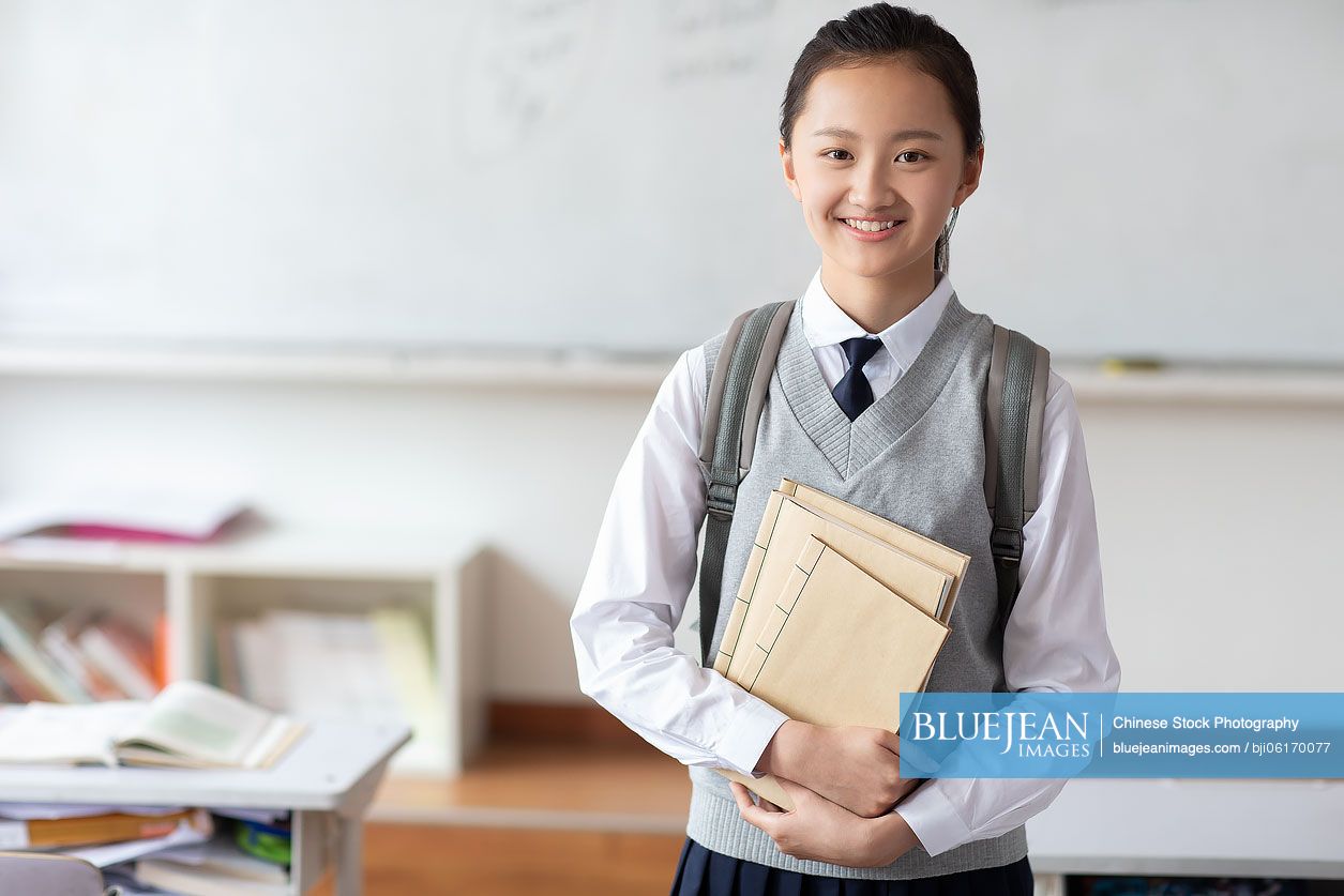 Chinese schoolgirl standing in classroom