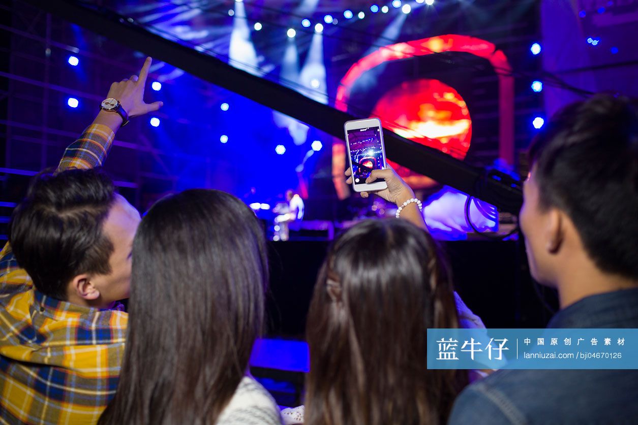 年轻女子在音乐节上用手机拍照