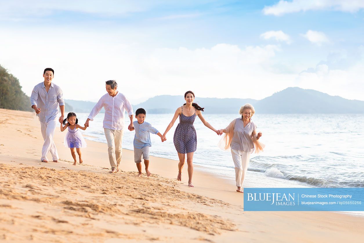 Happy Chinese family having fun on beach