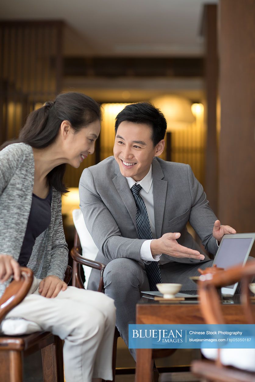 Confident Chinese businessman talking with a mature woman