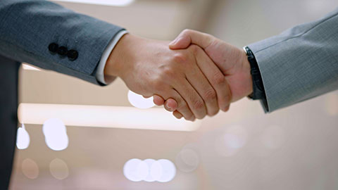 Successful Chinese business people shaking hands in office