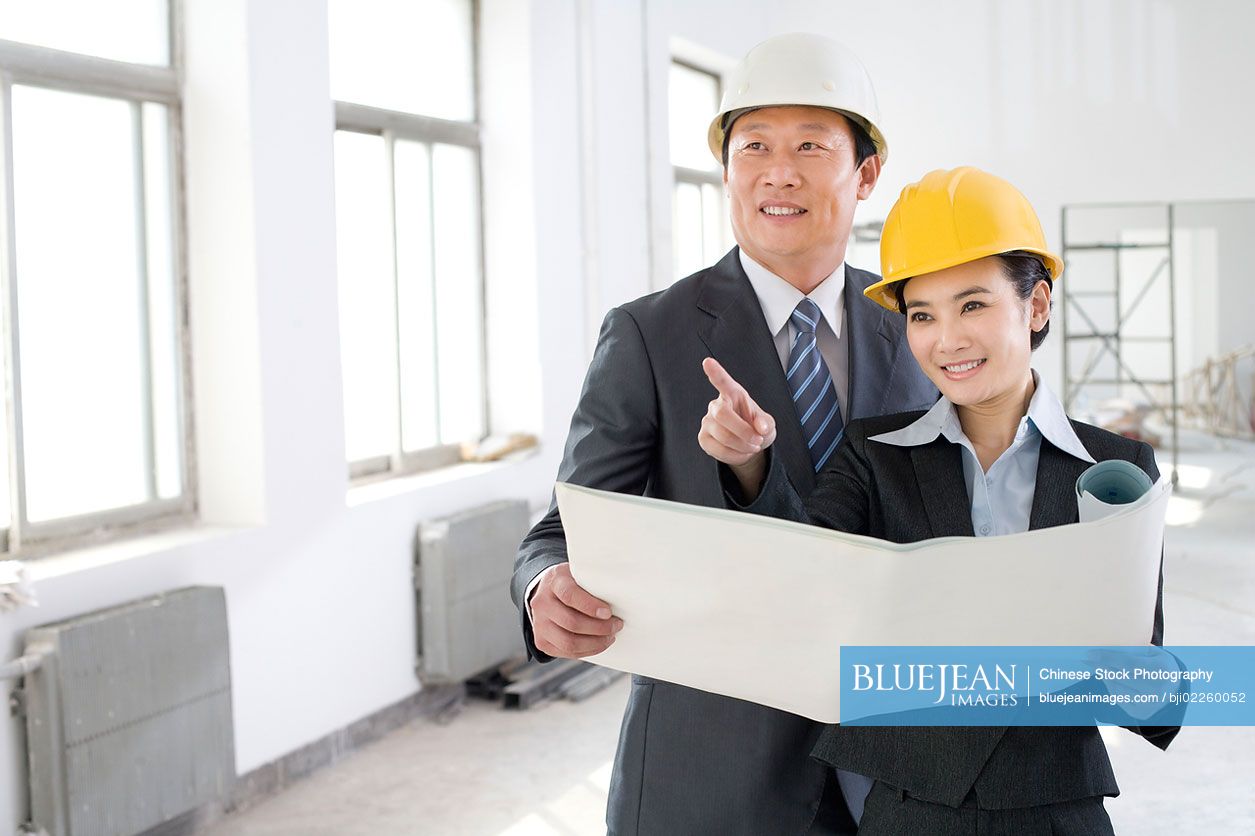 Two colleagues discussing a blueprint