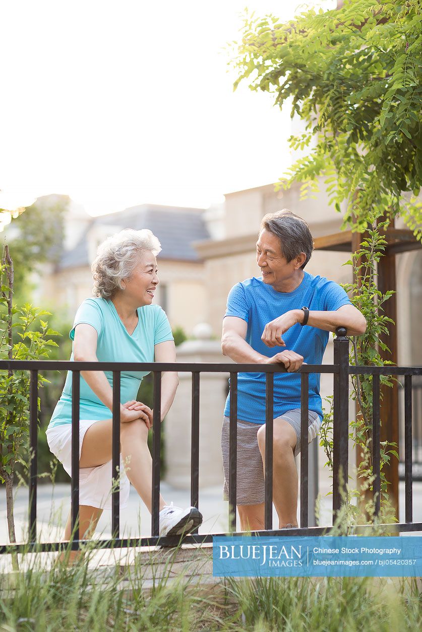 Cheerful senior Chinese couple exercising outside