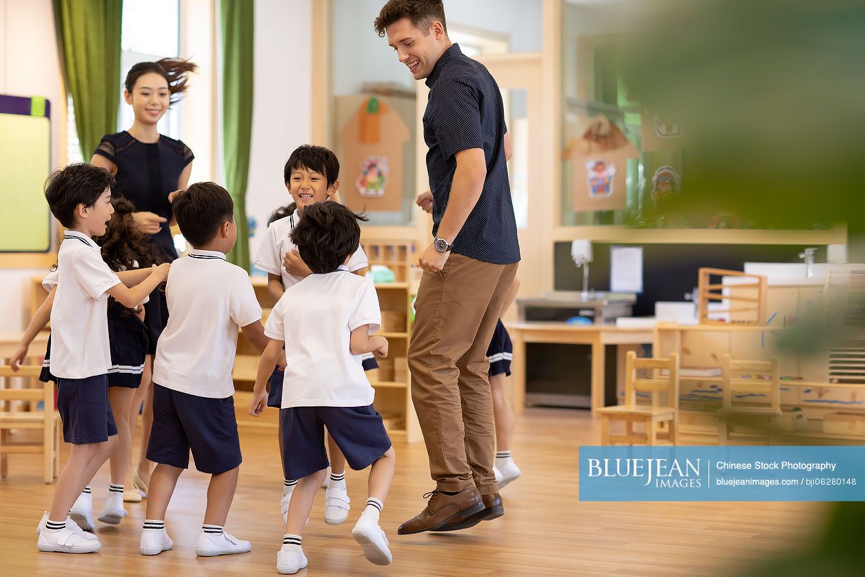 Teachers and children playing in classroom