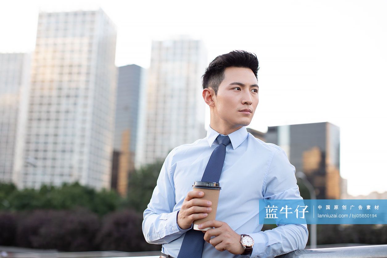 年轻商务男士拿着一杯咖啡
