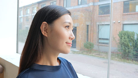 Young Chinese businesswoman looking through window,4K