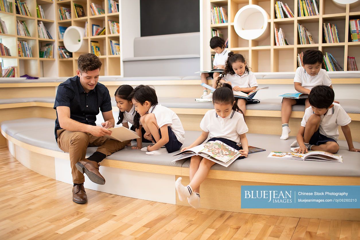 Children reading book in library
