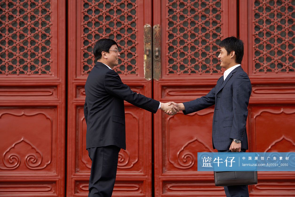 两位商务男士在太庙前握手