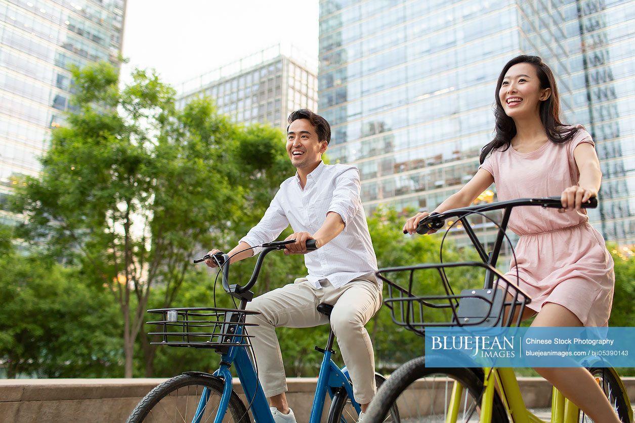 Happy young Chinese couple riding bikes