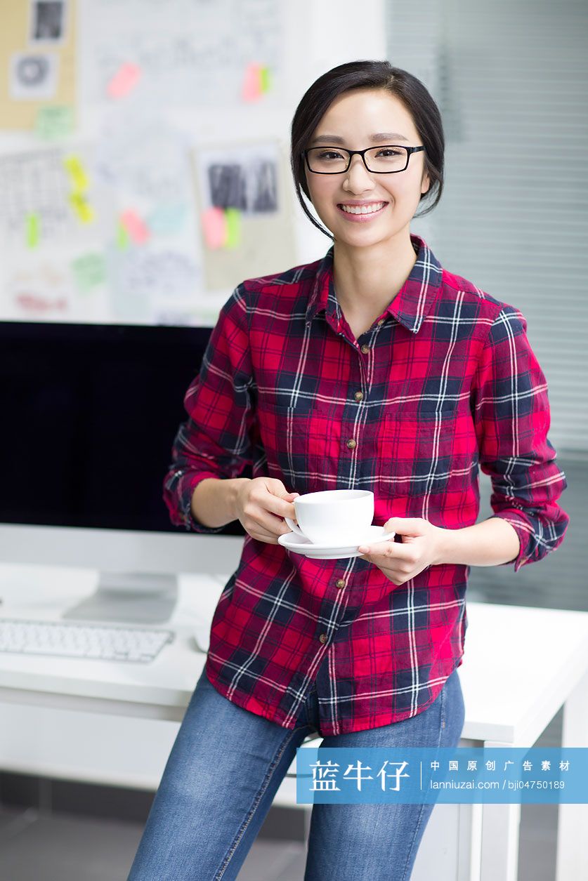 年轻女子在办公室喝咖啡