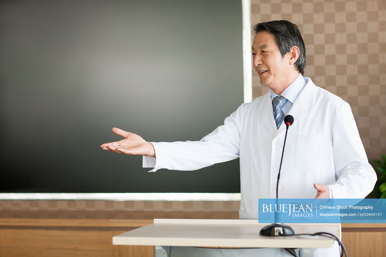 Senior male Chinese doctor giving a speech