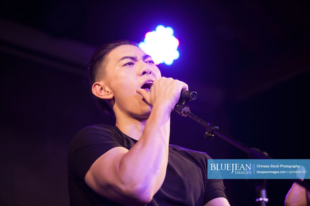 Young Chinese man singing on stage