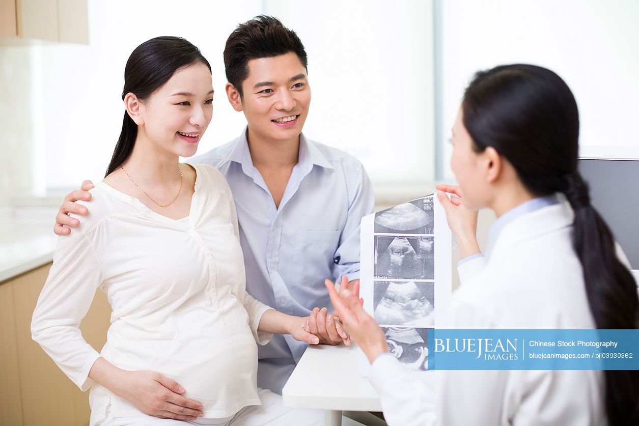 Pregnant Chinese woman and husband in doctor's office