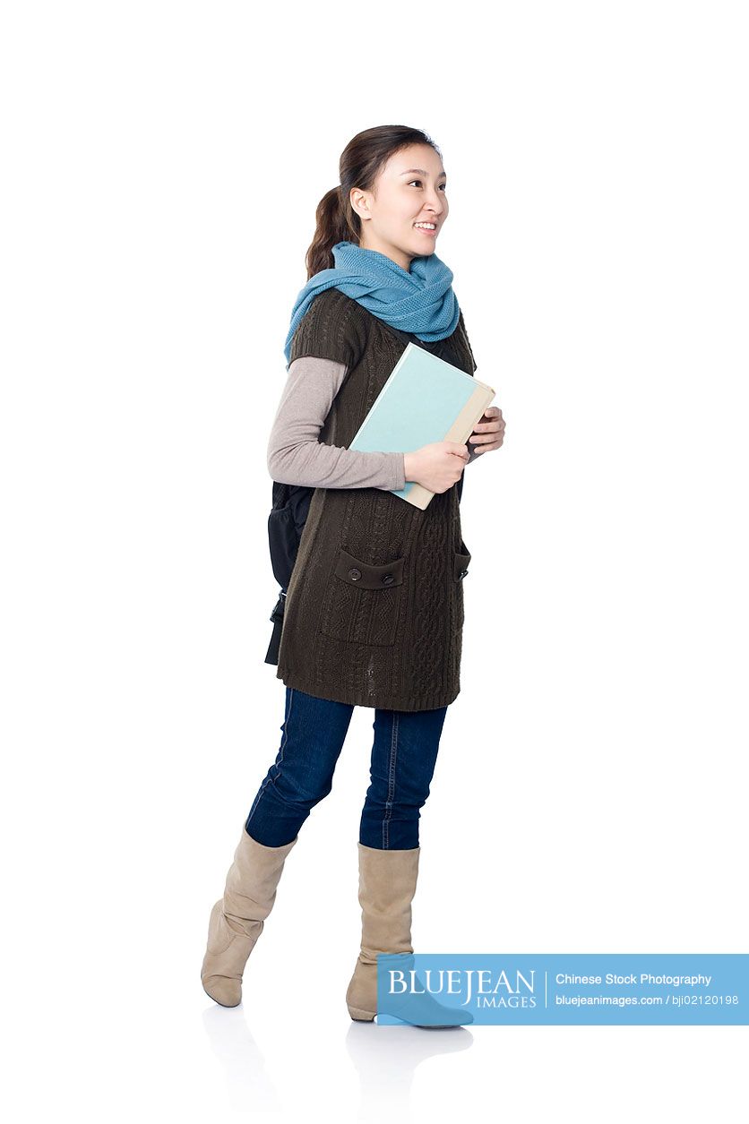 A young female Chinese student holding books, white background