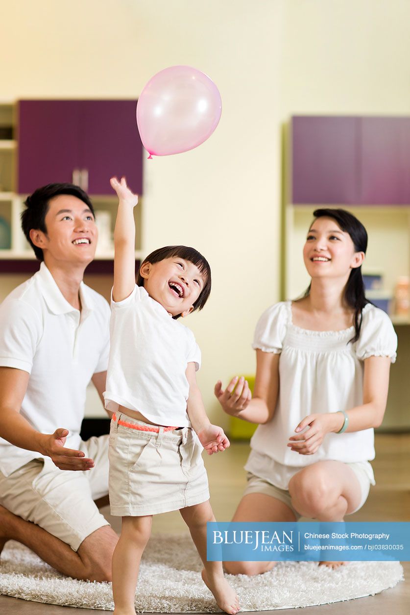 Young Chinese family playing balloon