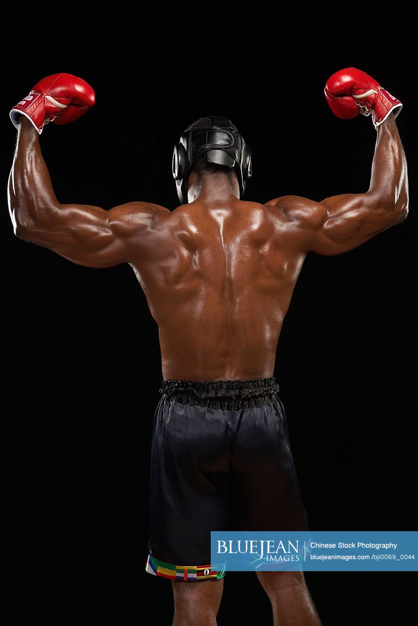 Rear View Of Boxer Flexing Muscles