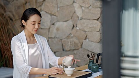 Elegant young Chinese woman drinking tea in tea room,4K