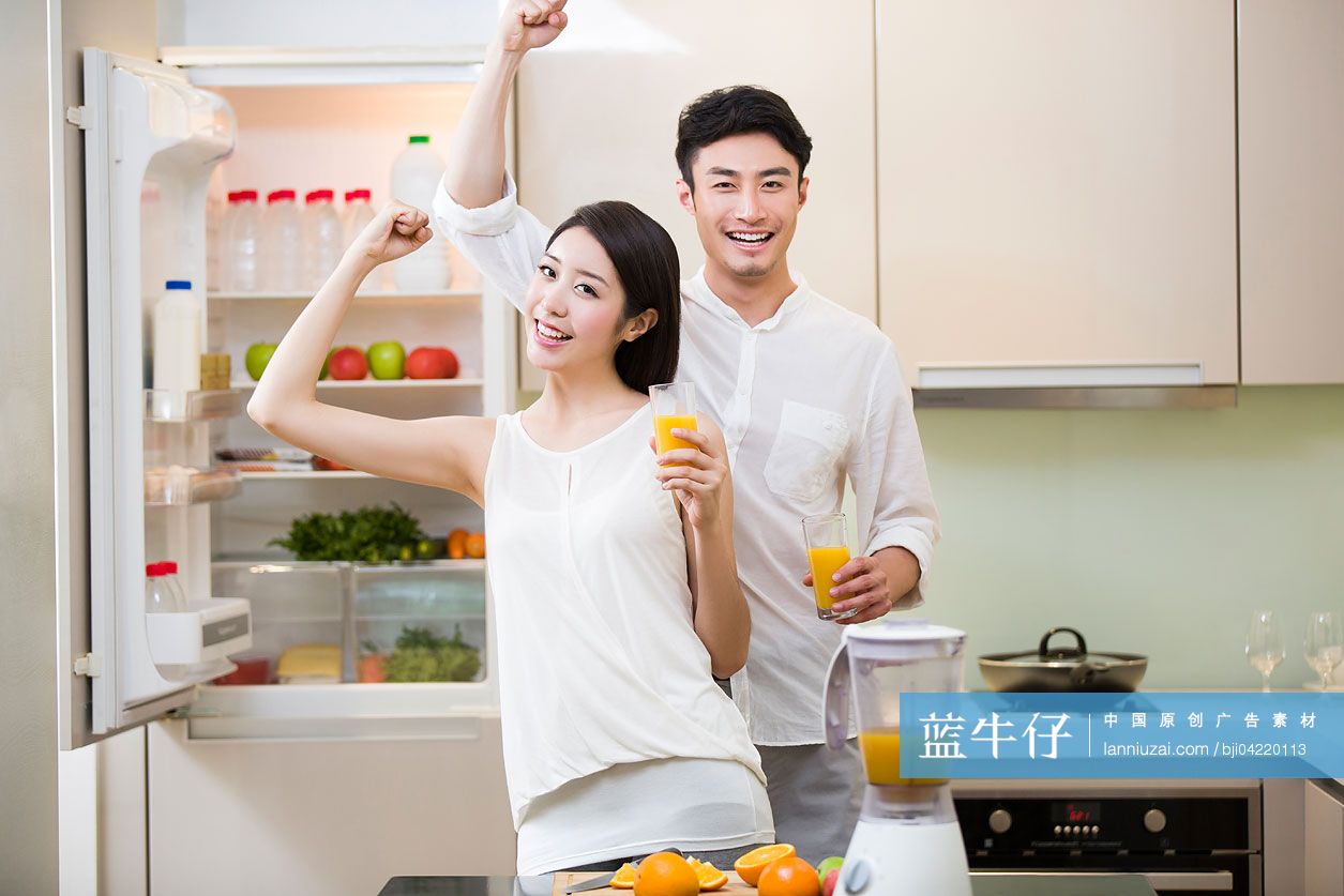 端着橙汁的年轻夫妇欢呼