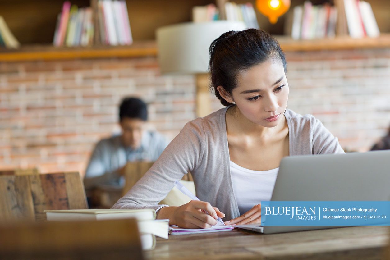 Young Chinese woman studying in cafe