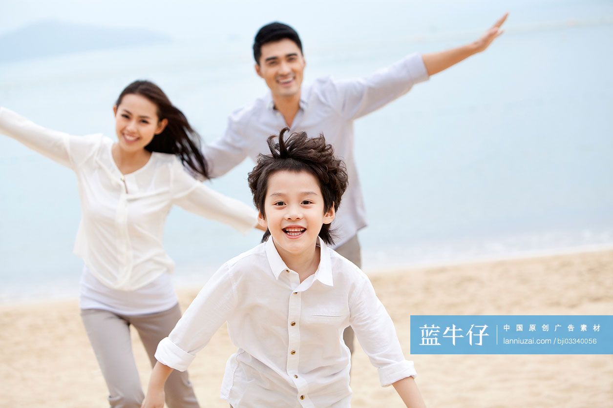 快乐的一家三口在沙滩上玩耍