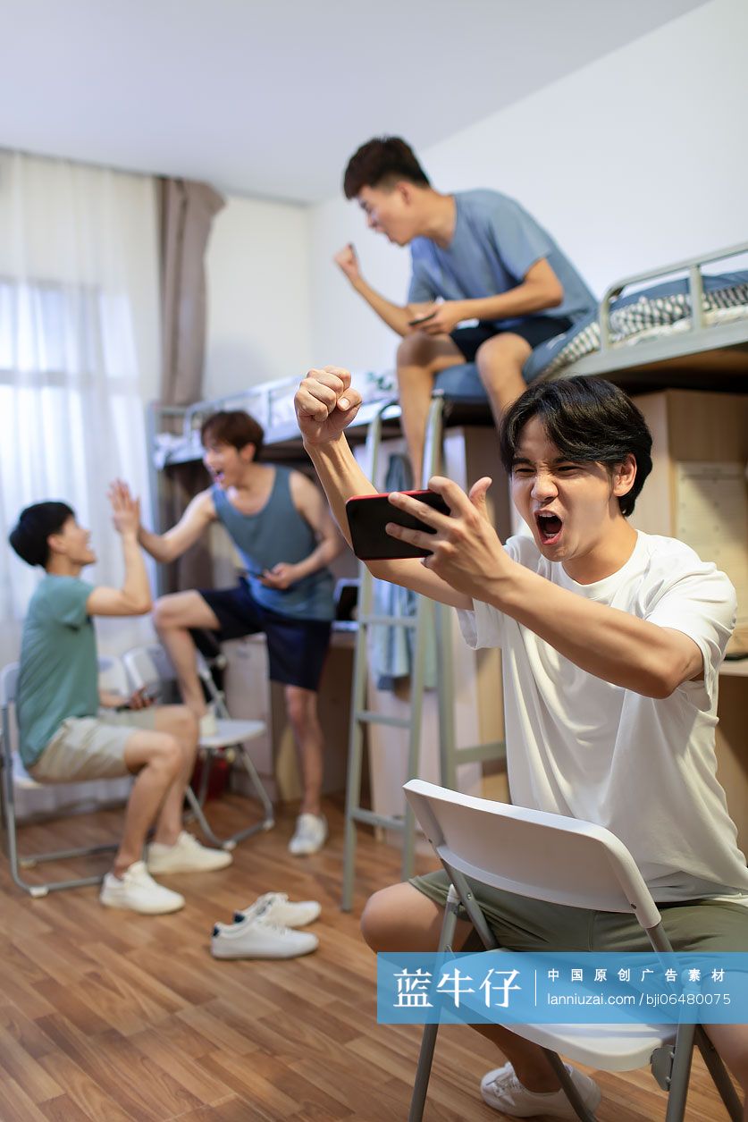 年轻大学生在宿舍玩手机游戏
