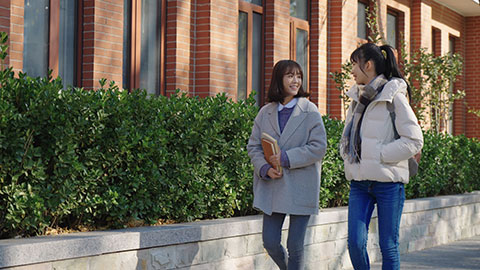 Happy Chinese college girls walking and talking