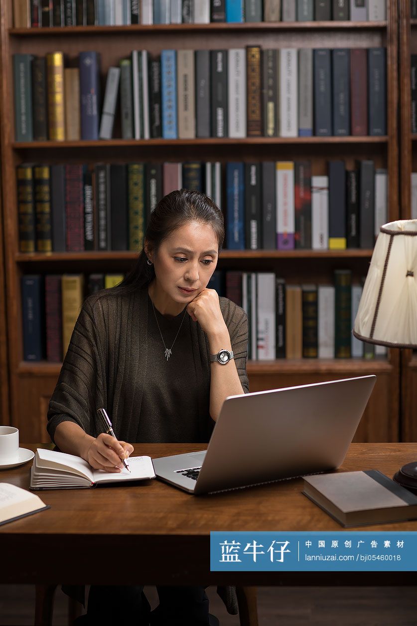 优雅的中年女士在书房使用笔记本电脑