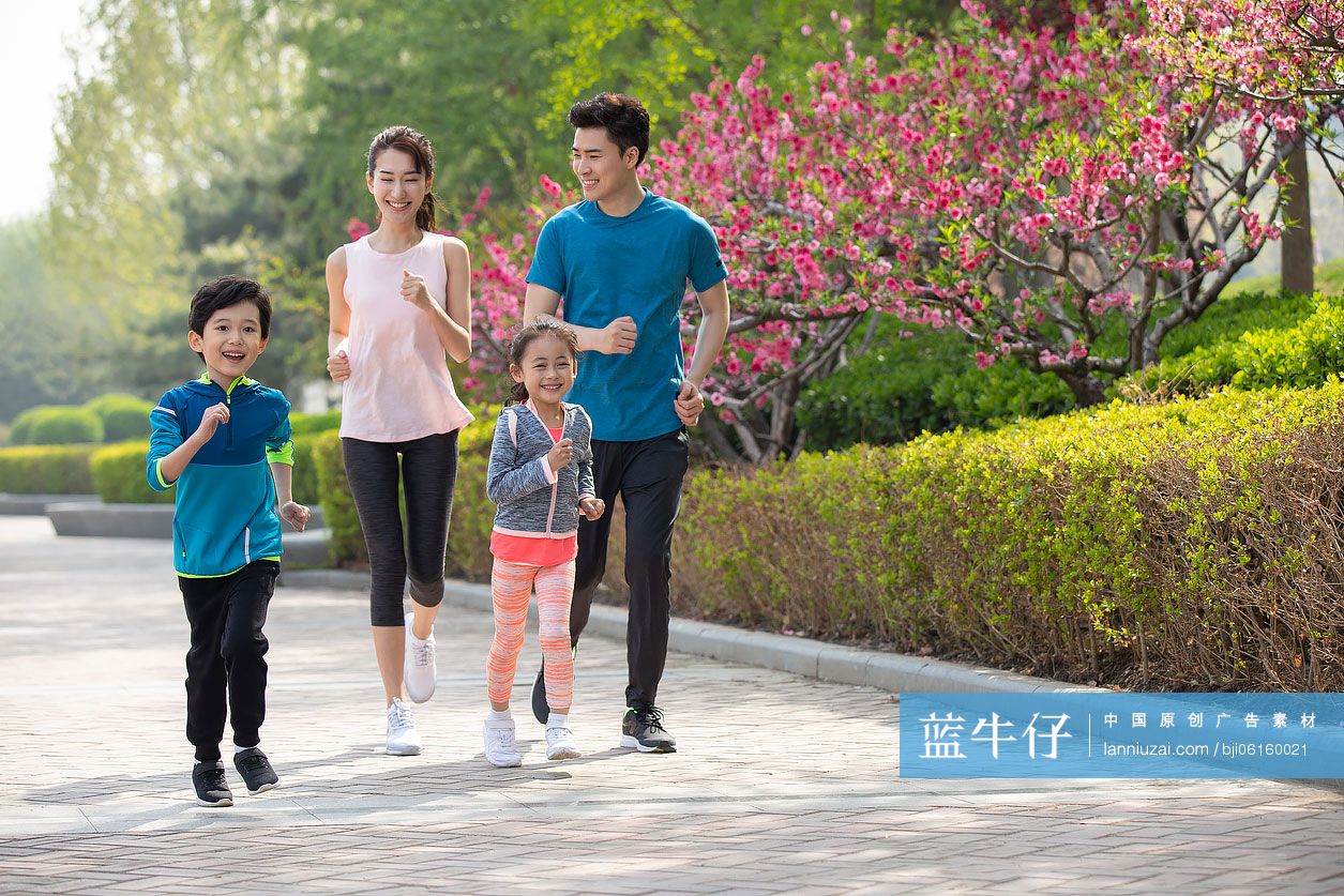 快乐的年轻家庭在公园跑步