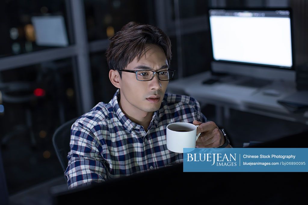 Chinese IT worker working in office at night