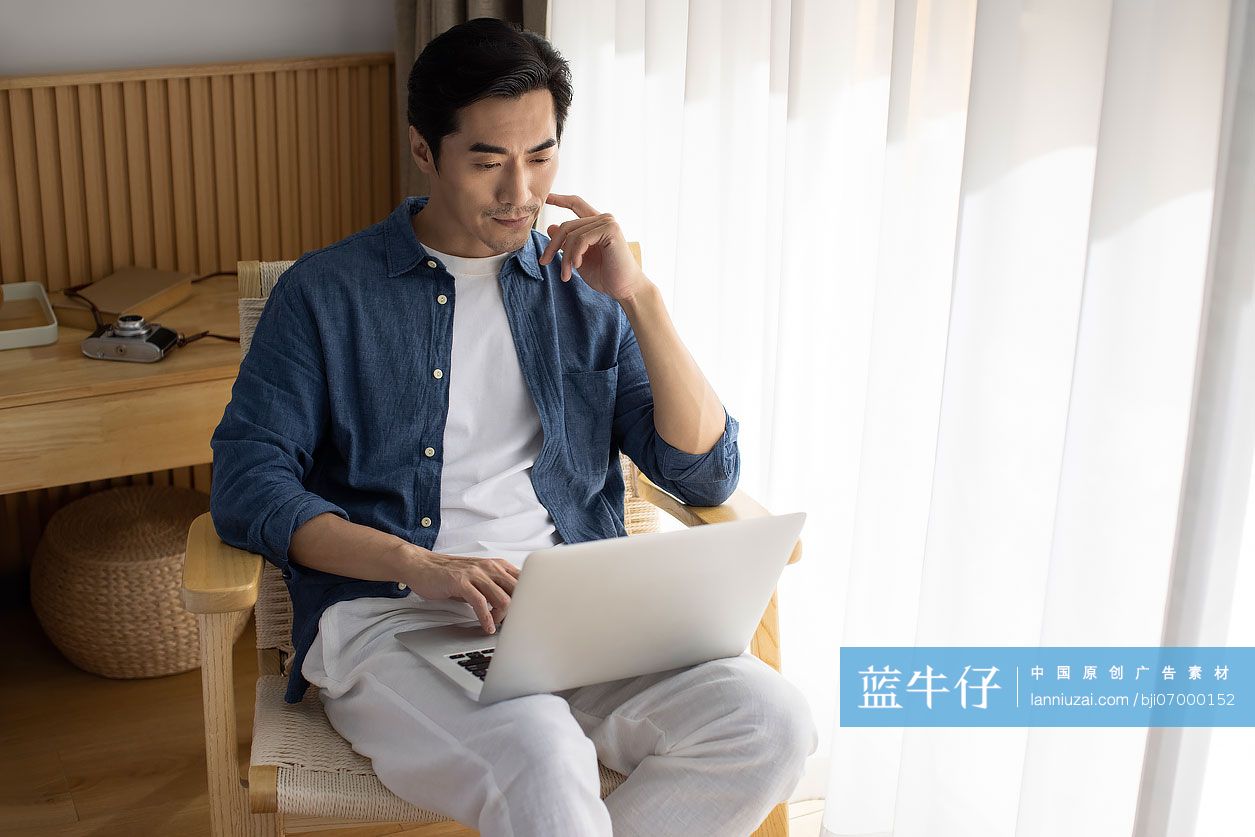 中年男子在家里使用笔记本电脑